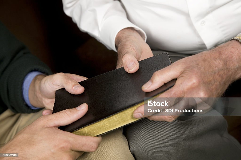 Horizontal vista de dois homens segurando uma Bíblia de couro preto - Foto de stock de Adulto royalty-free