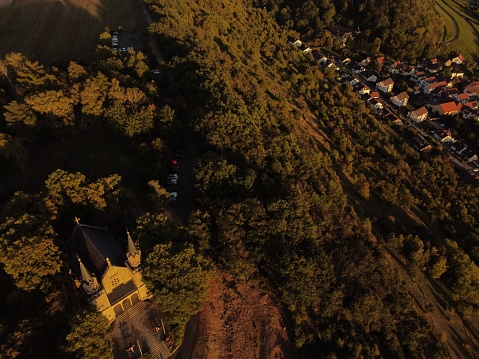 An aerial view of Zeil Chapel in the Bavarian countryside, surrounded by lush trees in the sunlight