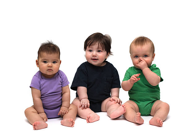 istock Three cute babies in different color onesies on a white back 173881705