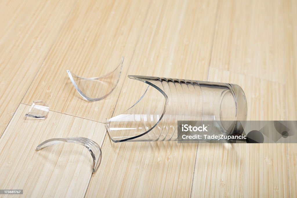 Broken glass on the floor Broken glass lying on the bamboo floor Shattered Glass Stock Photo