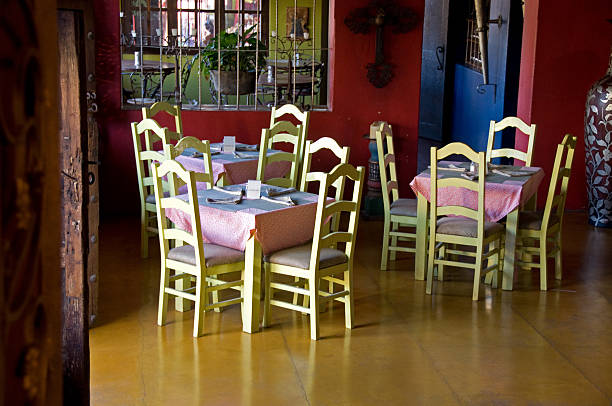 Tiled building with EXIT sign above doorway and visible restaurant seating in Bernal, Mexico