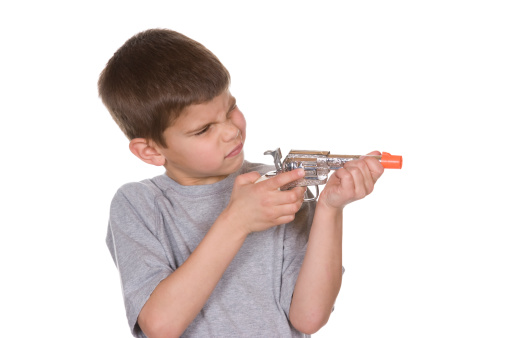 A small boy shooting a toy gun.