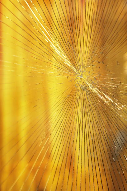 Vandalized broken window cracks emanate in all directions from the point of impact on the glass by some projectile.