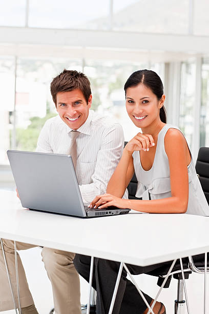 istock Smiling business colleagues working on laptop 173882697