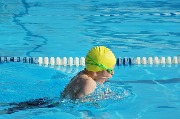 young boy carrera de natación estilo de natación en la piscina - braza fotografías e imágenes de stock