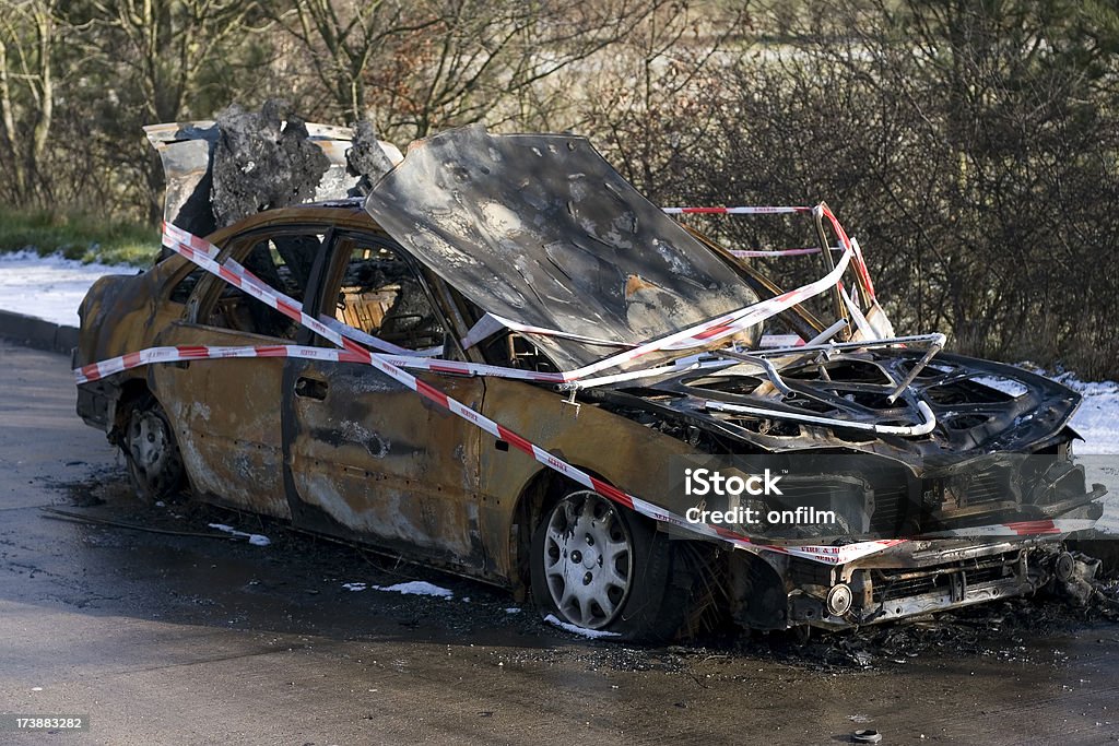 Burnt-out car wreck "A wrecked car on the roadside, burnt-out, and with emergency services tapes around it." Barricade Tape Stock Photo