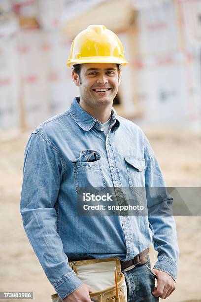 Construcción Hombre Que Agarra Blueprints Usando Cascos Foto de stock y más banco de imágenes de Accesorio de cabeza