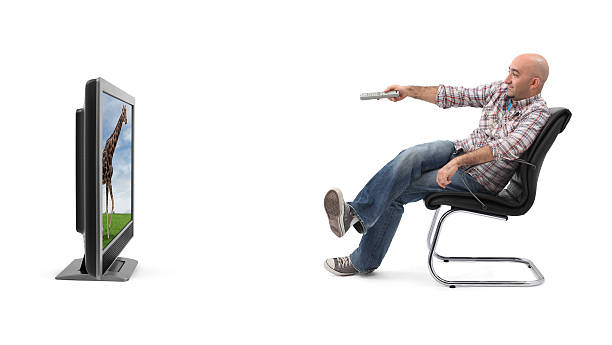 A man watching television with a remote  stock photo
