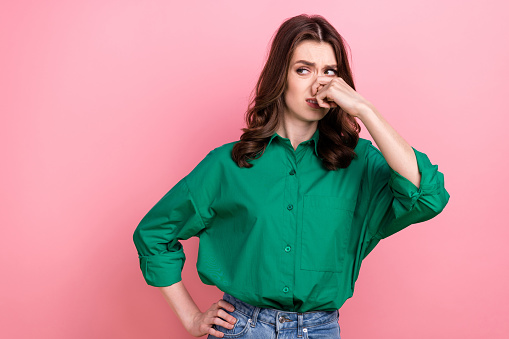 Photo of spoiled moody lady wear green shirt close nose looking empty space isolated pink color background.
