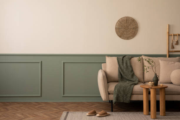 istock Creative composition of living room interior with copy space, beige sofa, green wall with stucco, wooden coffee table, brown slippers, gray plaid and personal accessories. Home decor. Template. 1738863582