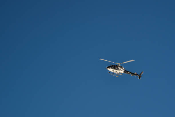 Jungfrau, Switzerland - Oct 20, 2018. Helicopter flying high in the blue sky, view from Jungfraujoch Peak (Switzerland).