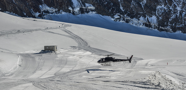 Helicopter flying on a mountain range.