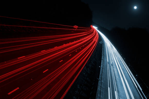 Blurred car lights from fast moving cars on motorway Blurred Car Headlight and Taillights Driving on a motoway from an overhead bridge reflector stock pictures, royalty-free photos & images
