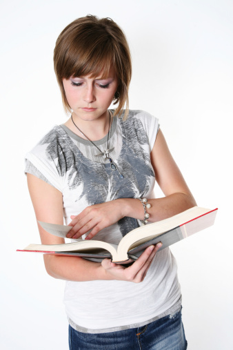 teen female student reading a textbook