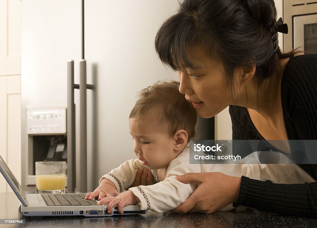 Joven Madre y bebé jugando en ordenador portátil - Foto de stock de 0-11 meses libre de derechos