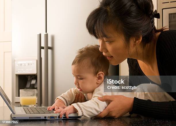 Joven Madre Y Bebé Jugando En Ordenador Portátil Foto de stock y más banco de imágenes de 0-11 meses - 0-11 meses, 20 a 29 años, 25-29 años