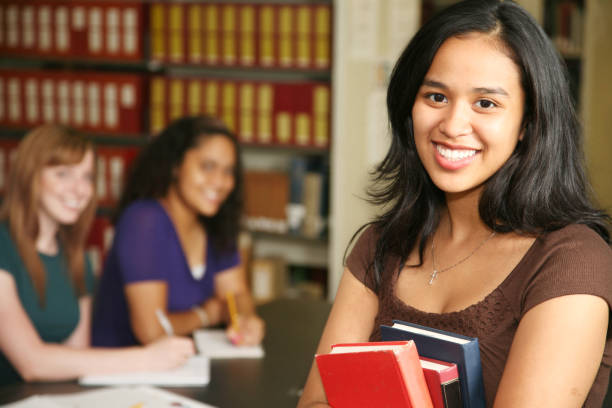 istock Smiling Female Student holding Books and with her Classmates 173888019