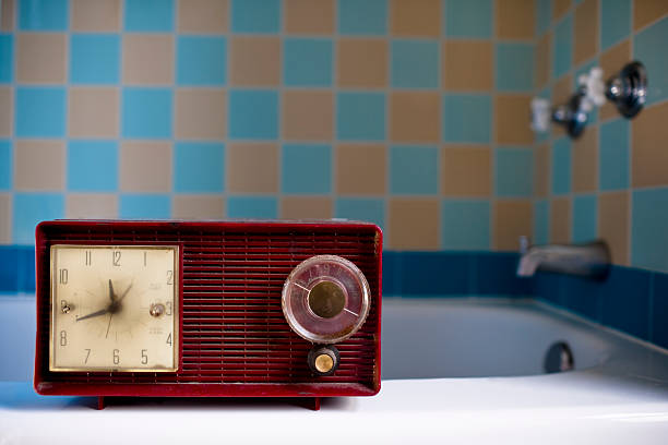 red vintage retro radio sitting on bath tub ledge red retro vintage style radio in a retro inspired bathroom radio retro revival old old fashioned stock pictures, royalty-free photos & images