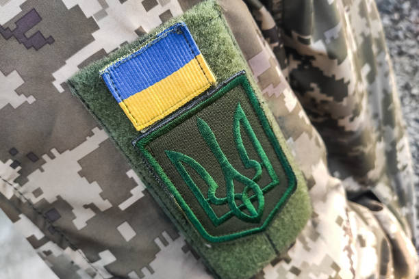 uniforme militare mimetica pixel texture ravvicinata delle forze armate, tridente chevron e bandiera dell'ucraina - oggetto generale foto e immagini stock