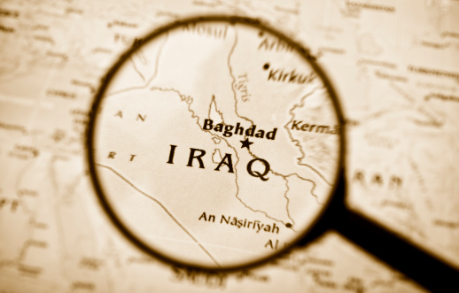 High resolution photograph of a magnifying glass over Iraq in a map. 