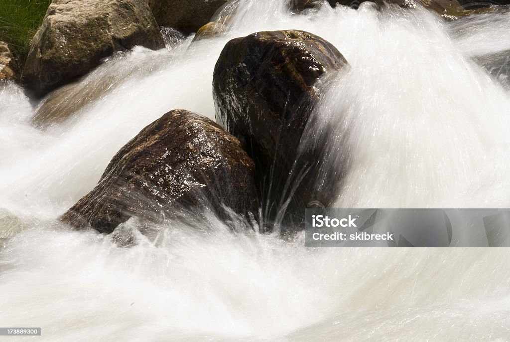 Borrosa agua que fluye Over Rocks in a River - Foto de stock de Agua libre de derechos