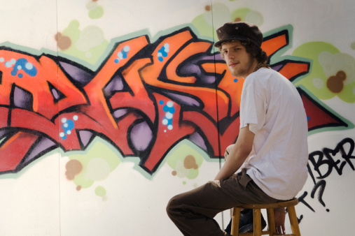 Subject: A graffiti artist working on his wall.