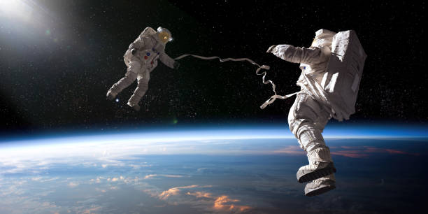 dos astronautas en una caminata espacial atada uno frente al otro - astronaut space zero gravity spacewalk fotografías e imágenes de stock