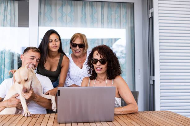 nietos, madre y abuela pasando tiempo juntos en la terraza de la casa mientras usan la computadora portátil - family pets dog multi generation family fotografías e imágenes de stock