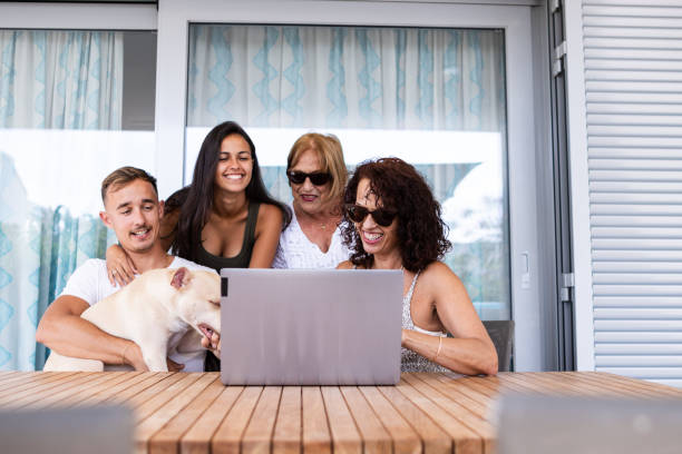 toda la familia navega por internet con una computadora portátil mientras están juntos en casa - family pets dog multi generation family fotografías e imágenes de stock