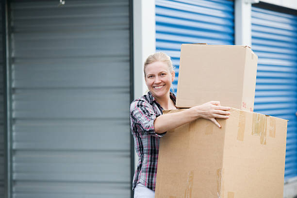 Woman Holding Boxes Outside Self Storage Unit stock photo