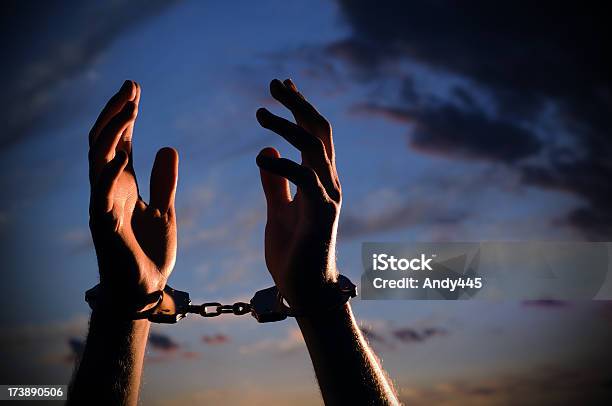 Closeup Image Of Hands With Handcuffs Lifted In Despair Stock Photo - Download Image Now