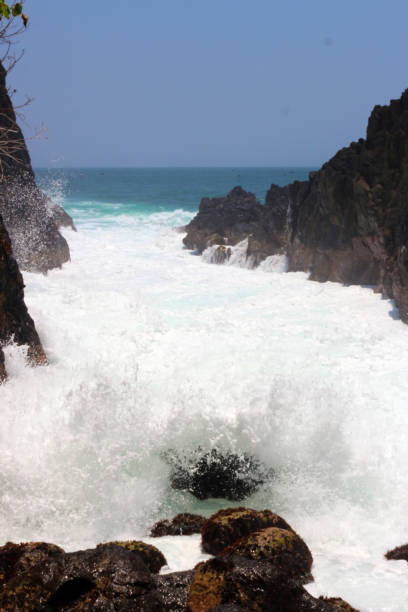 istock Powerful waves crashing rocks in the seashore. 1738906375