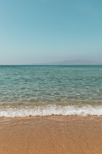 Sunny beach and turquoise sea with clear sky background