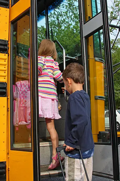 Detail of US schoolbus with children getting into the bus.