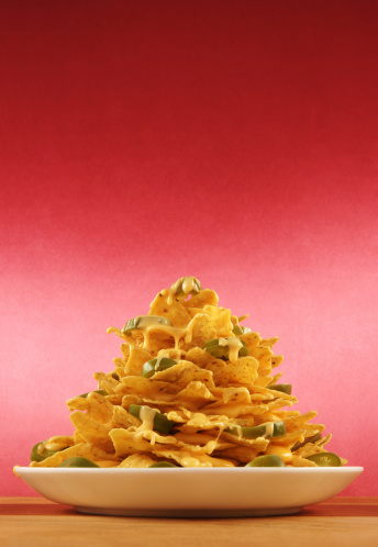 Big plate of fast-food style nachos; with chips, cheese sauce, and jalepenos!  Plenty of room for copy above, or make your own falling stream of nacho cheese.