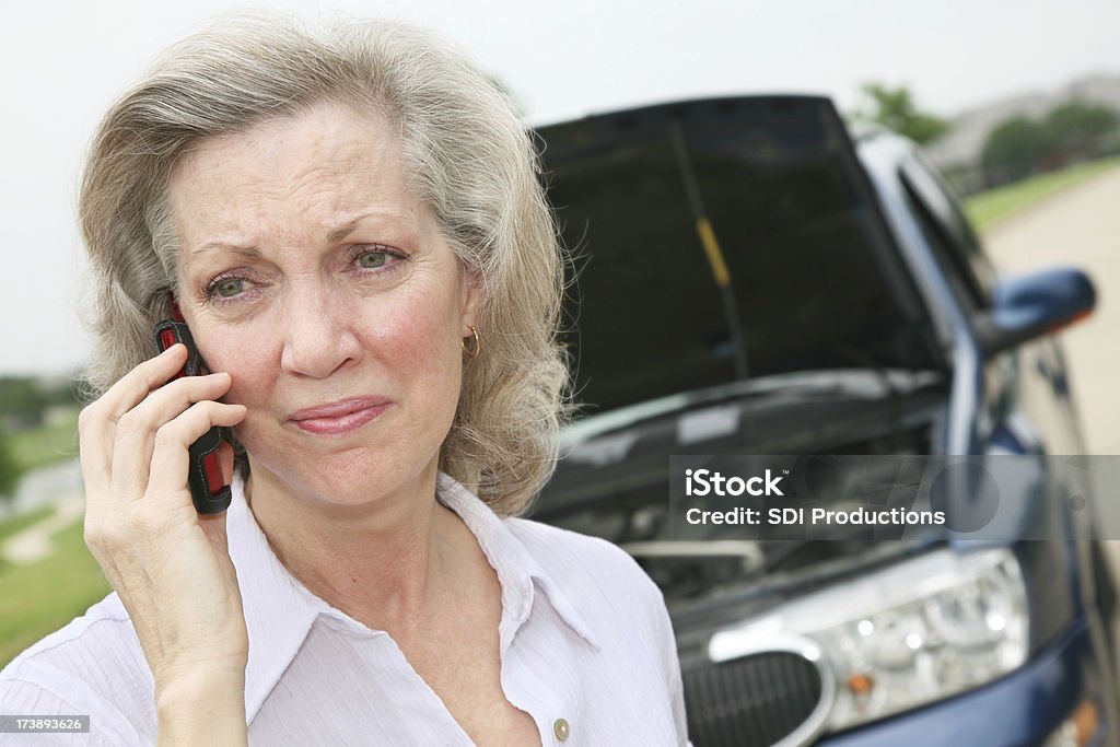 Kobieta stojąc przez jej podziale pojazdu - Zbiór zdjęć royalty-free (50-59 lat)