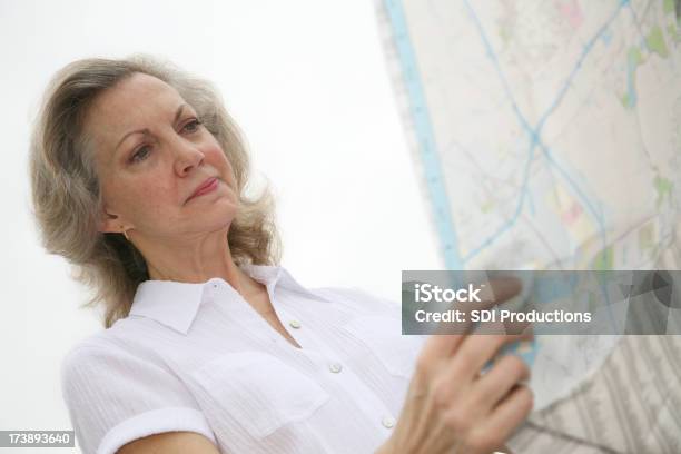 Isolato Anziani Donna Guardando Una Mappa - Fotografie stock e altre immagini di Adulto - Adulto, Ambientazione esterna, Assistenza