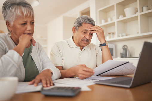 Debt, stress and senior couple with financial, bills and budget at computer with paperwork. Anxiety, banking problem and savings planning for pension and retirement in a home with web tax notes