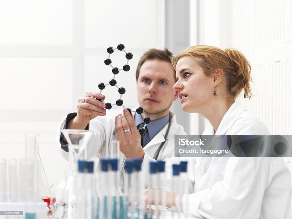 Investigadora y médico examinar una estructura molecular - Foto de stock de 25-29 años libre de derechos