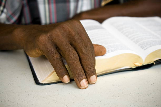 A senior african man resting his hand on the Bible.