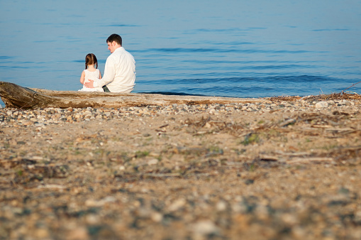 Color photo of a father and daughter spending time together on the beach.