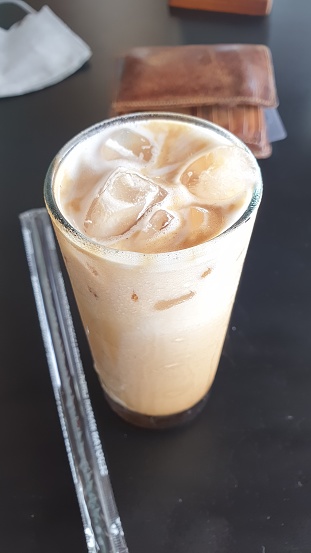 Indulge in the sheer pleasure of a chilled glass of iced coffee, complete with a handy straw. A delightful caffeine fix awaits
