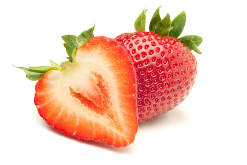 Fresh ripe red strawberries on white.  The strawbery in front is sliced in half.