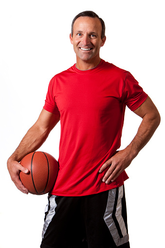 a happy, athletic 40-45 year old male with a basketball under his arm. isolated on a white background.