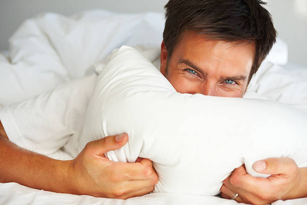 istock Young man covering his face with pillow 173894815