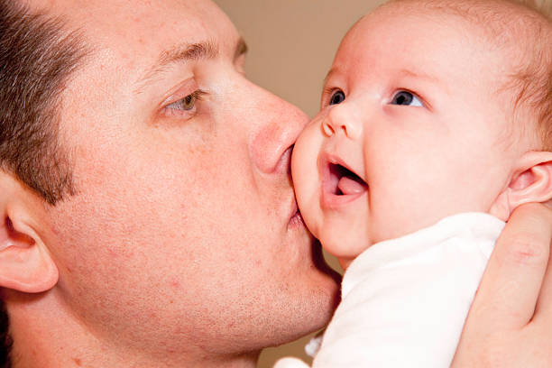 istock Dad kissing his happy baby 173895826