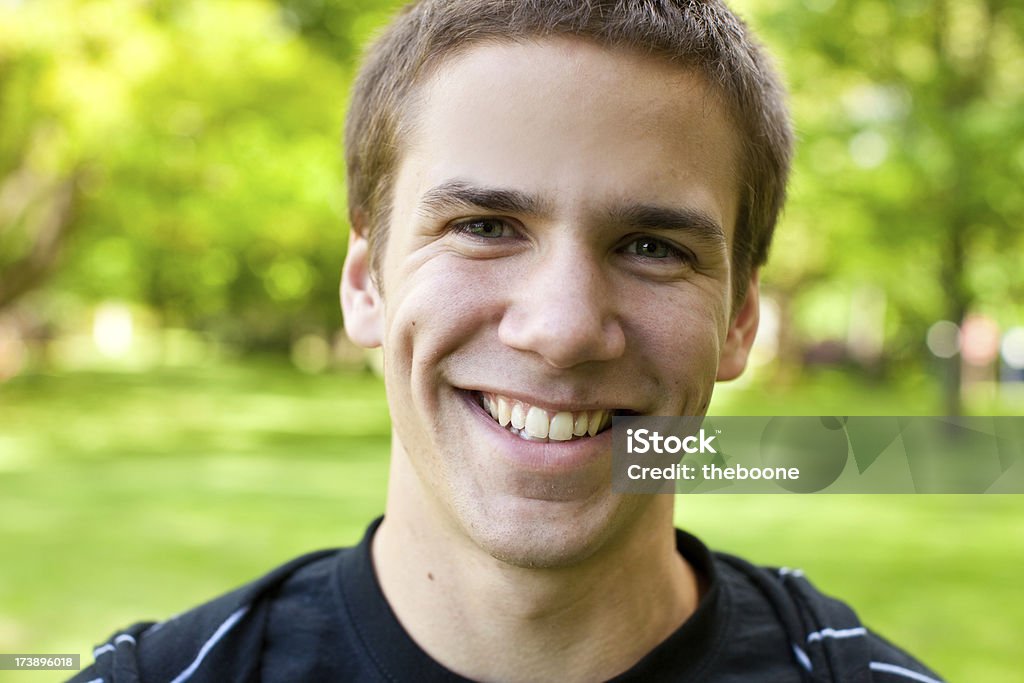 Retrato de um jovem sorrindo para a câmera no parque - Foto de stock de Olhar para a Câmera royalty-free