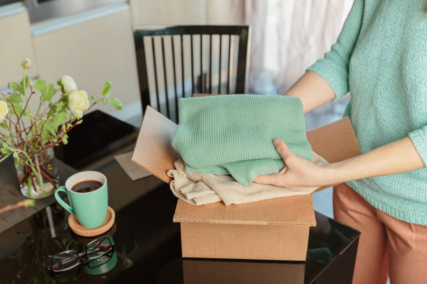 istock Woman packing box with used wardrobe for resale 1738960565