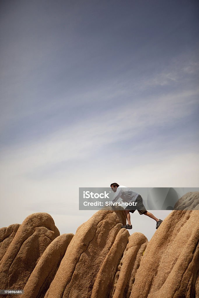 Hombre tantas dificultades para conseguir más de rocas del desierto - Foto de stock de Adversidad libre de derechos