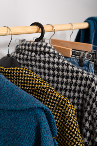 different woolen coats on clothes hangers
